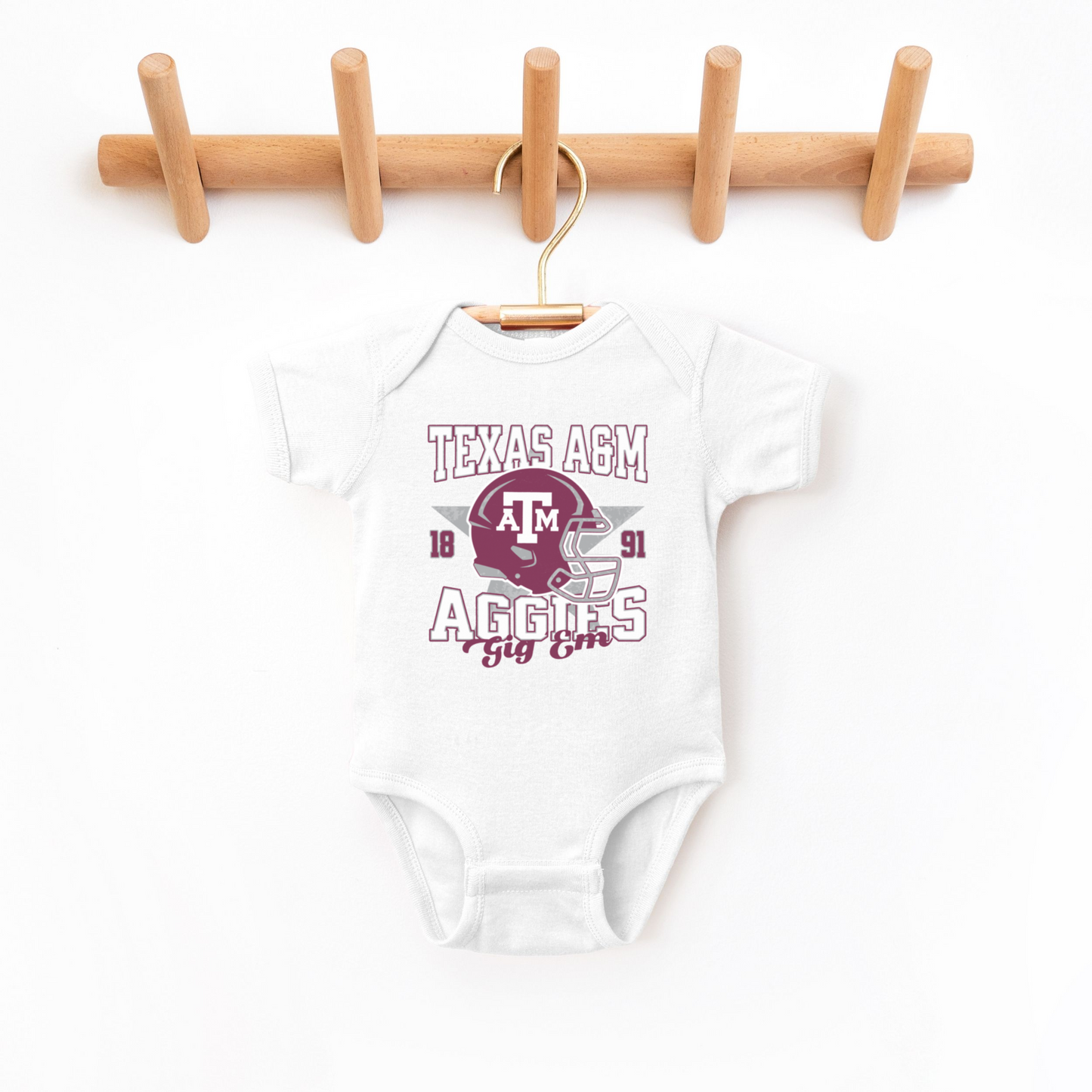 The White Texas A&M Aggies Football Bodysuit lays flat on a white background. The Texas A&M Aggies Football graphic is in bold Multicolor in a Varsity style.
