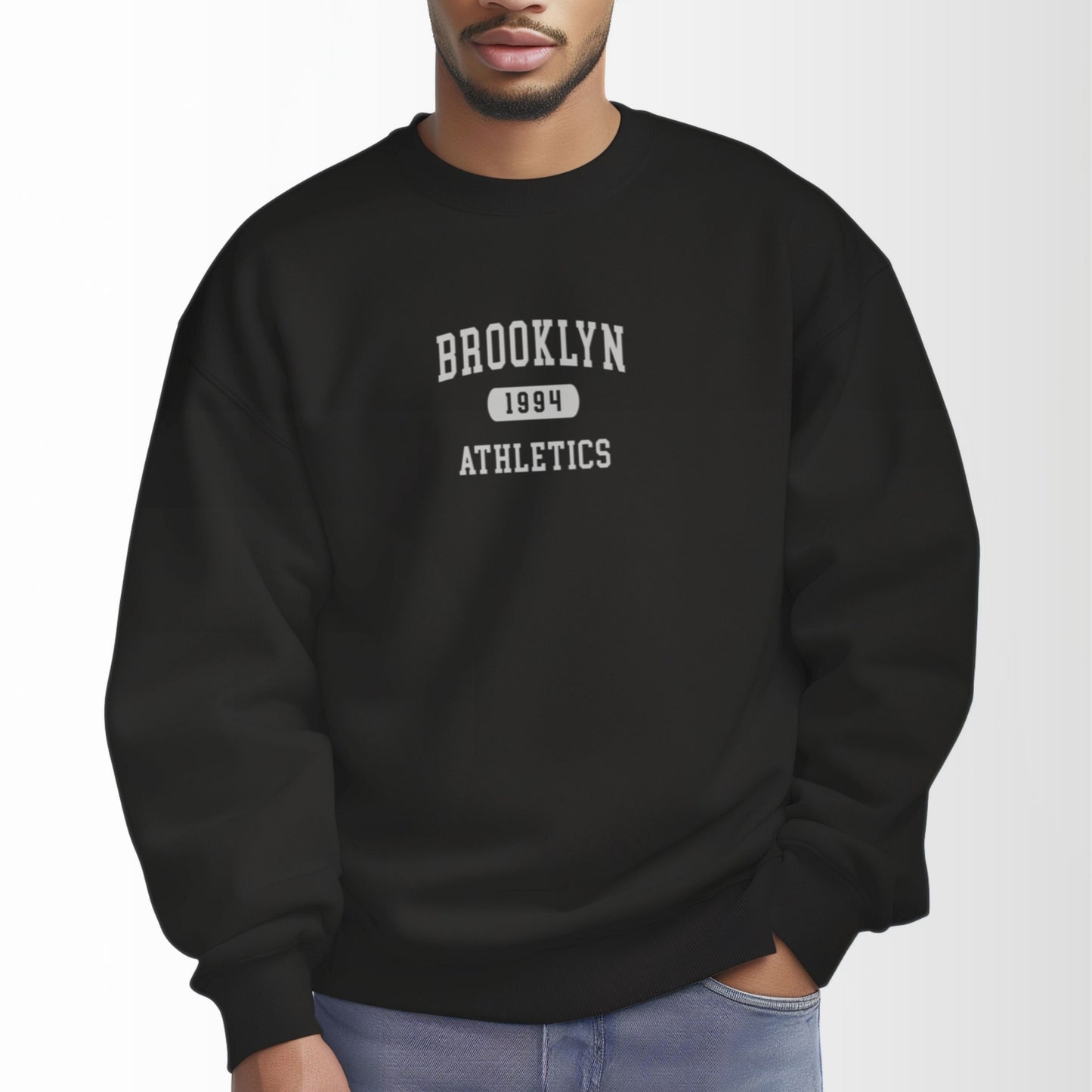 A model wears the Black Brooklyn Athletics Crewneck Sweatshirt.  The ﻿Brooklyn Athletics﻿ graphic is in bold White in a Varsity style.