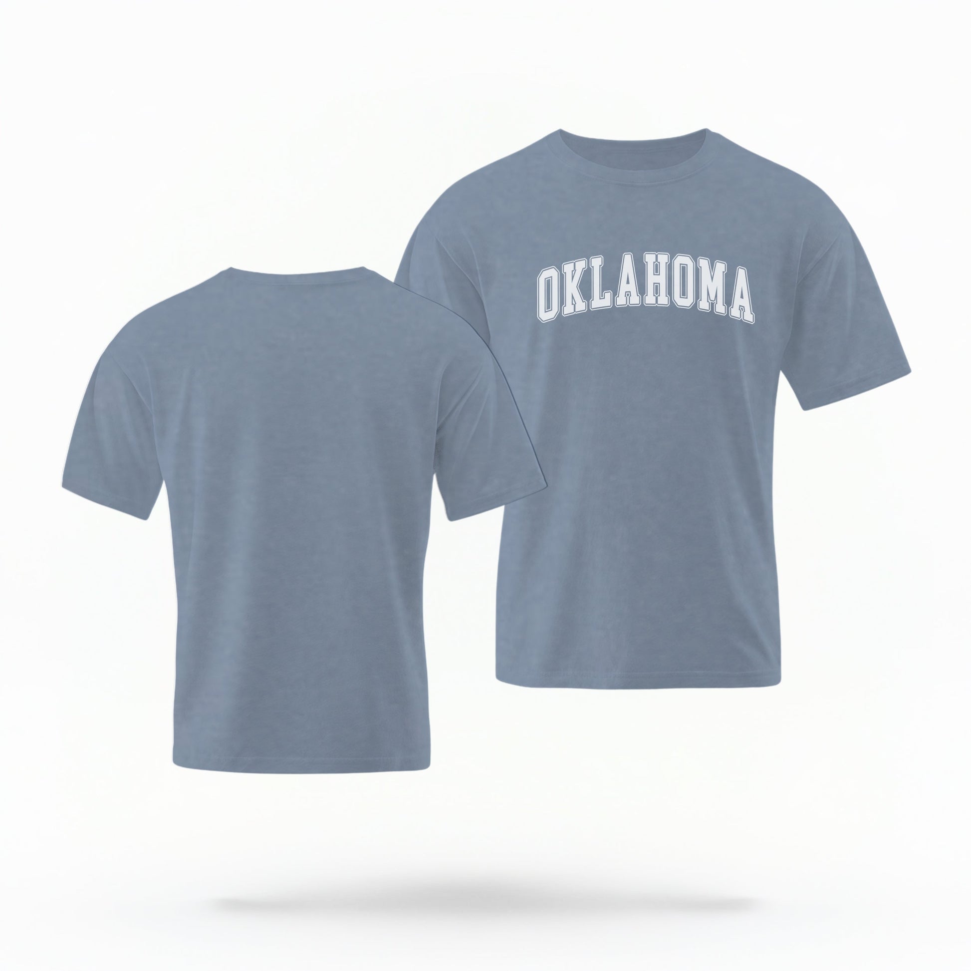 The Blue Jeans Unisex Oklahoma Varsity Comfort Colors T-shirt lays flat on a white background. The Oklahoma graphic is in bold white in a varsity offset style.