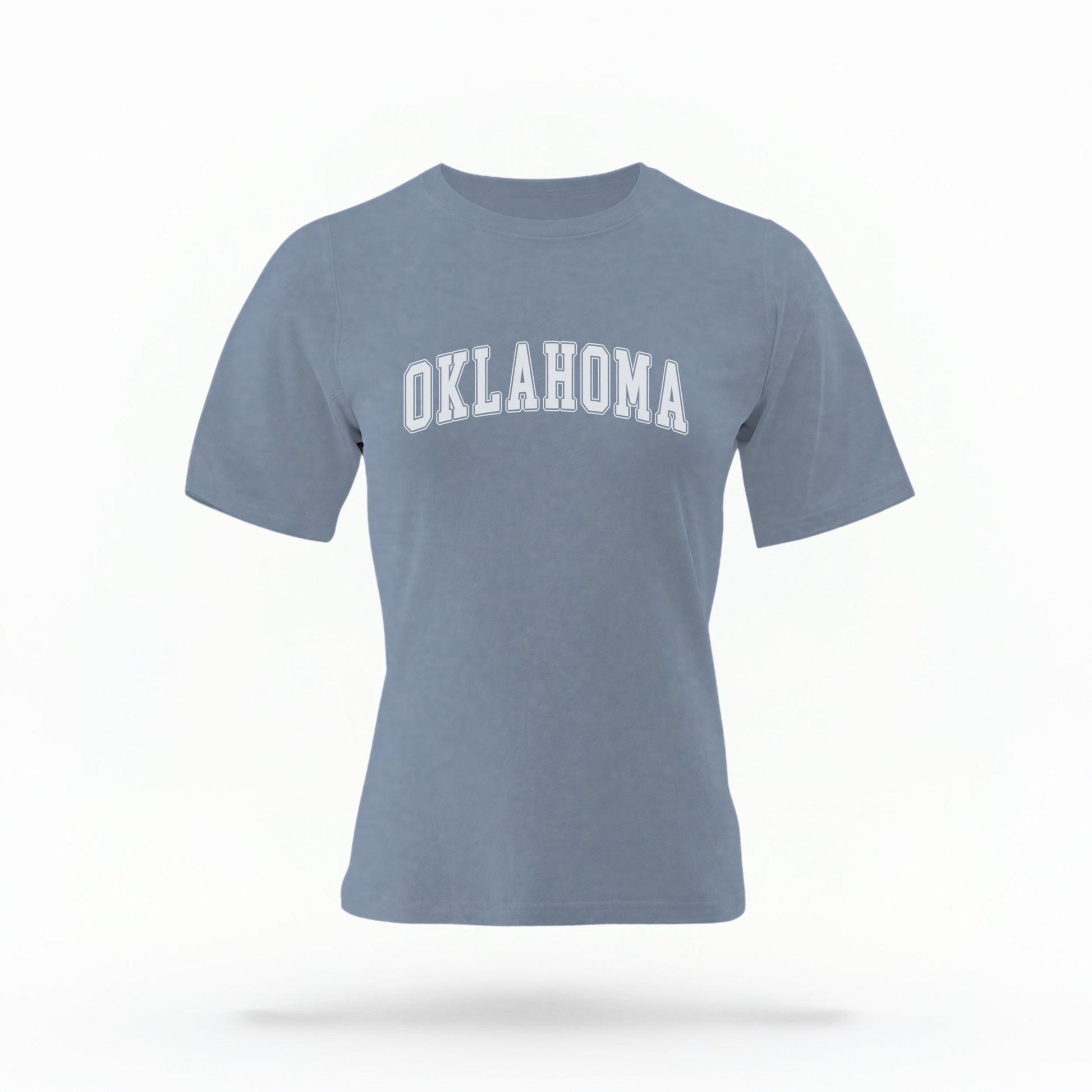 The Blue Jeans Unisex Oklahoma Varsity Comfort Colors T-shirt lays flat on a white background. The Oklahoma graphic is in bold white in a varsity offset style.