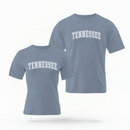 The Blue Jeans Unisex Tennessee Varsity Comfort Colors T-shirt lays flat on a white background. The Tennessee graphic is in bold white in a varsity offset style.