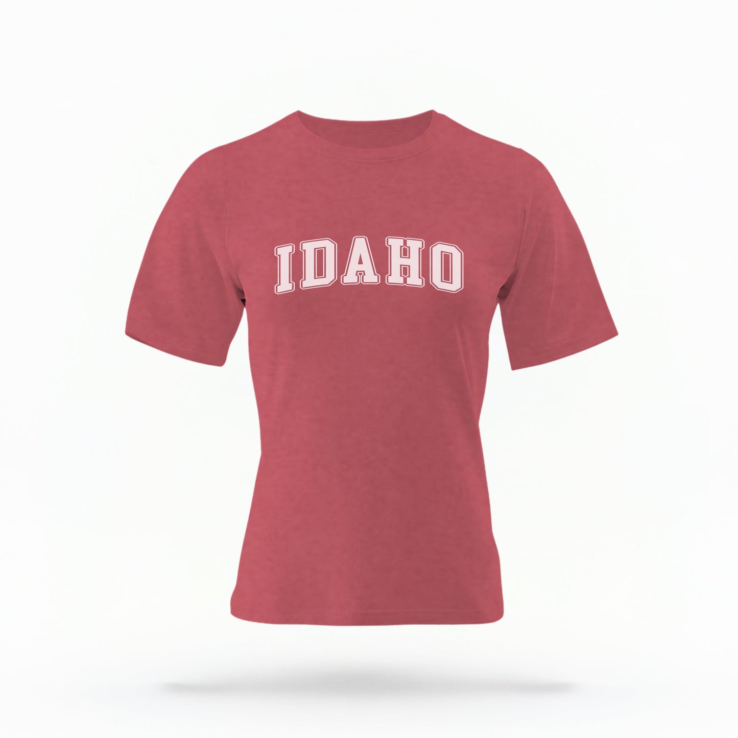 The Crimson Unisex Idaho Varsity Comfort Colors T-shirt lays flat on a white background. The Idaho graphic is in bold white in a varsity offset style.