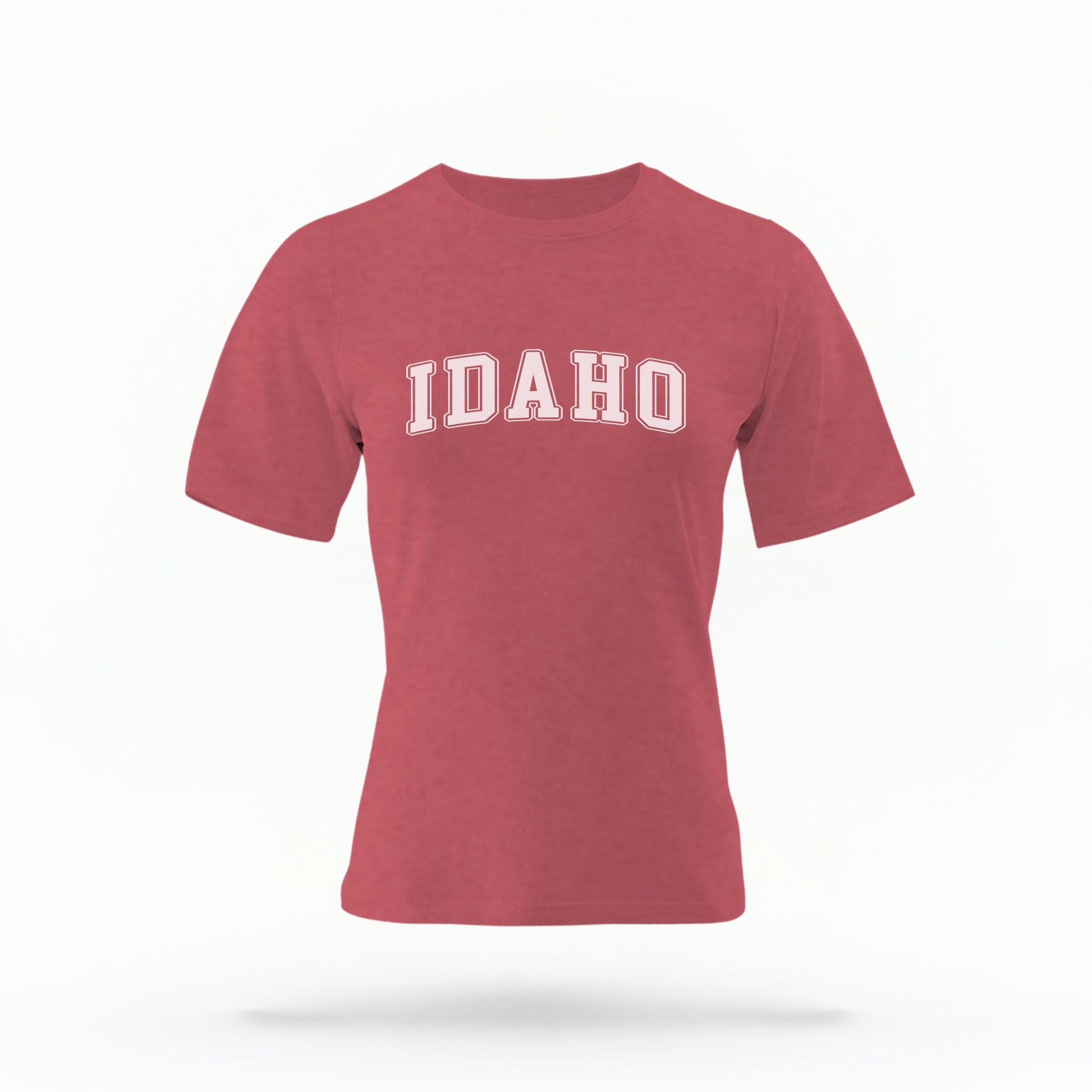 The Crimson Unisex Idaho Varsity Comfort Colors T-shirt lays flat on a white background. The Idaho graphic is in bold white in a varsity offset style.