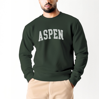 A model wears the Forest Green Aspen Colorado Varsity Crewneck Sweatshirt.  The ﻿Aspen Colorado Varsity﻿ graphic is in bold White in a Collegiate style.