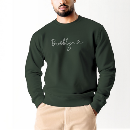 A model wears the Forest Green Adult Unisex Brooklyn NY Dainty Crewneck Sweatshirt.  The ﻿Brooklyn NY Dainty﻿ graphic is in bold White in a Script style.