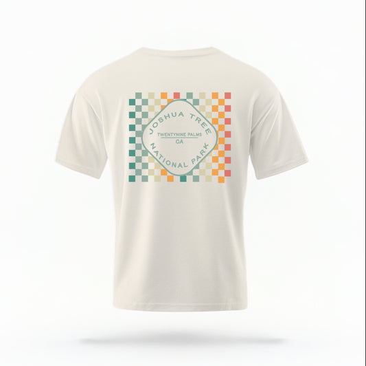 The Ivory Joshua Tree Retro Checkered Comfort Colors T-shirt lays flat on a white background. The ﻿Joshua Tree Retro Checkered﻿ graphic is in bold Multicolor in a Retro style.