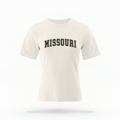 The Ivory Unisex Missouri Varsity Comfort Colors T-shirt lays flat on a white background. The Missouri graphic is in bold black in a varsity offset style.