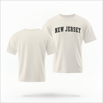 The ivory Unisex New Jersey Varsity Comfort Colors T-shirt lays flat on a white background. The New Jersey graphic is in bold black in a varsity offset style.