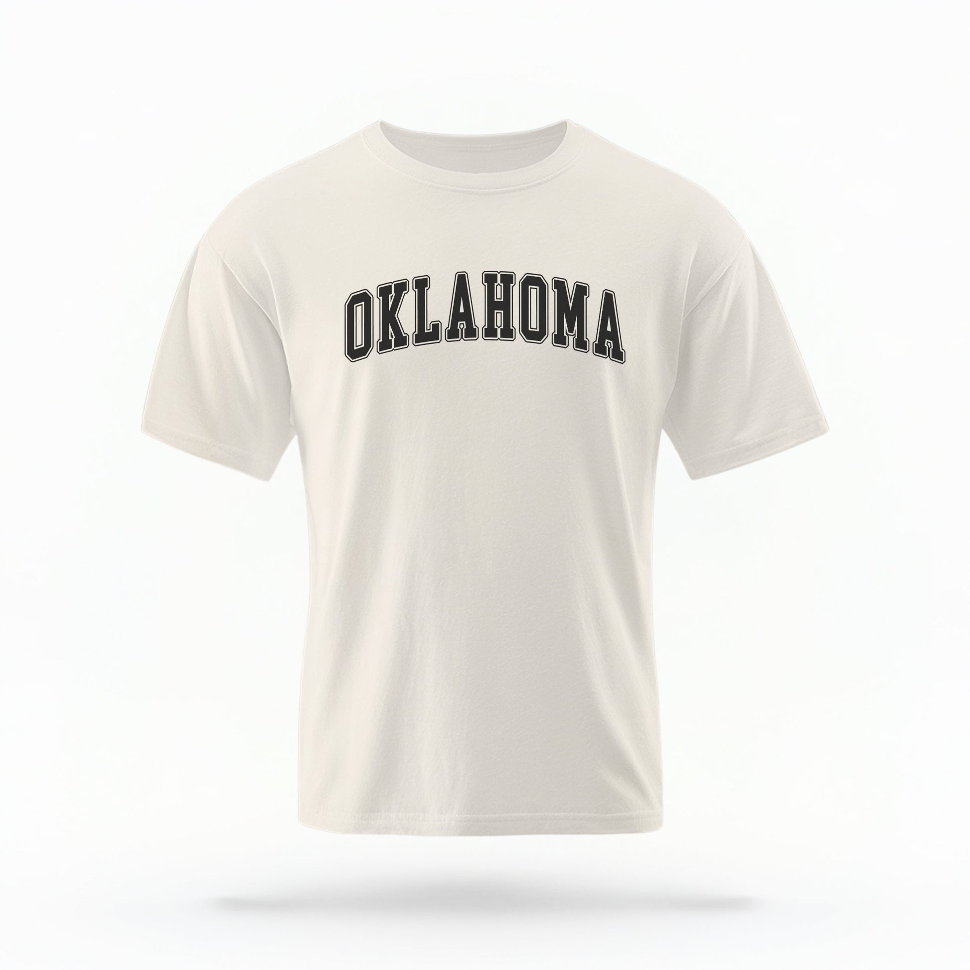 The ivory Unisex Oklahoma Varsity Comfort Colors T-shirt lays flat on a white background. The Oklahoma graphic is in bold black in a varsity offset style.