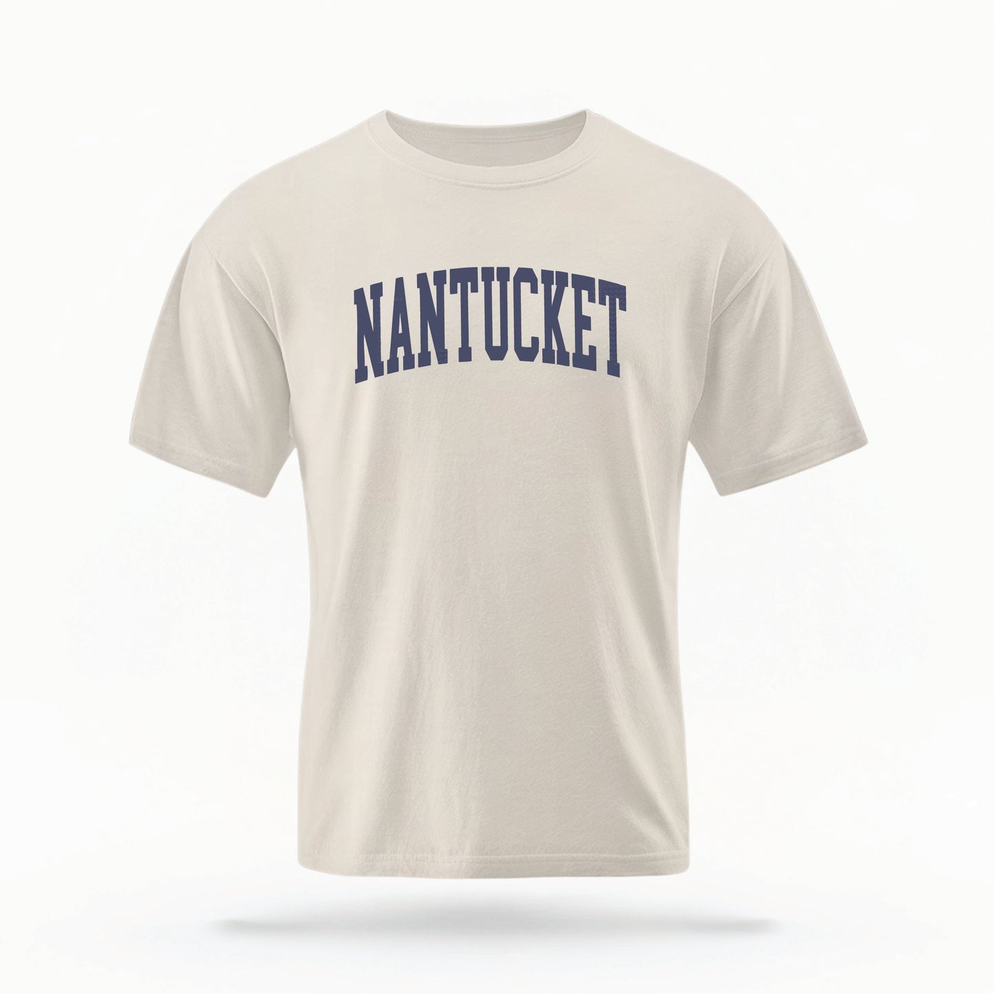 The Ivory Adult Unisex Nantucket Massachusetts Varsity Comfort Colors T-shirt lays flat on a white background. The ﻿Nantucket Massachusetts Varsity﻿ graphic is in bold Navy in a Collegiate Block style.