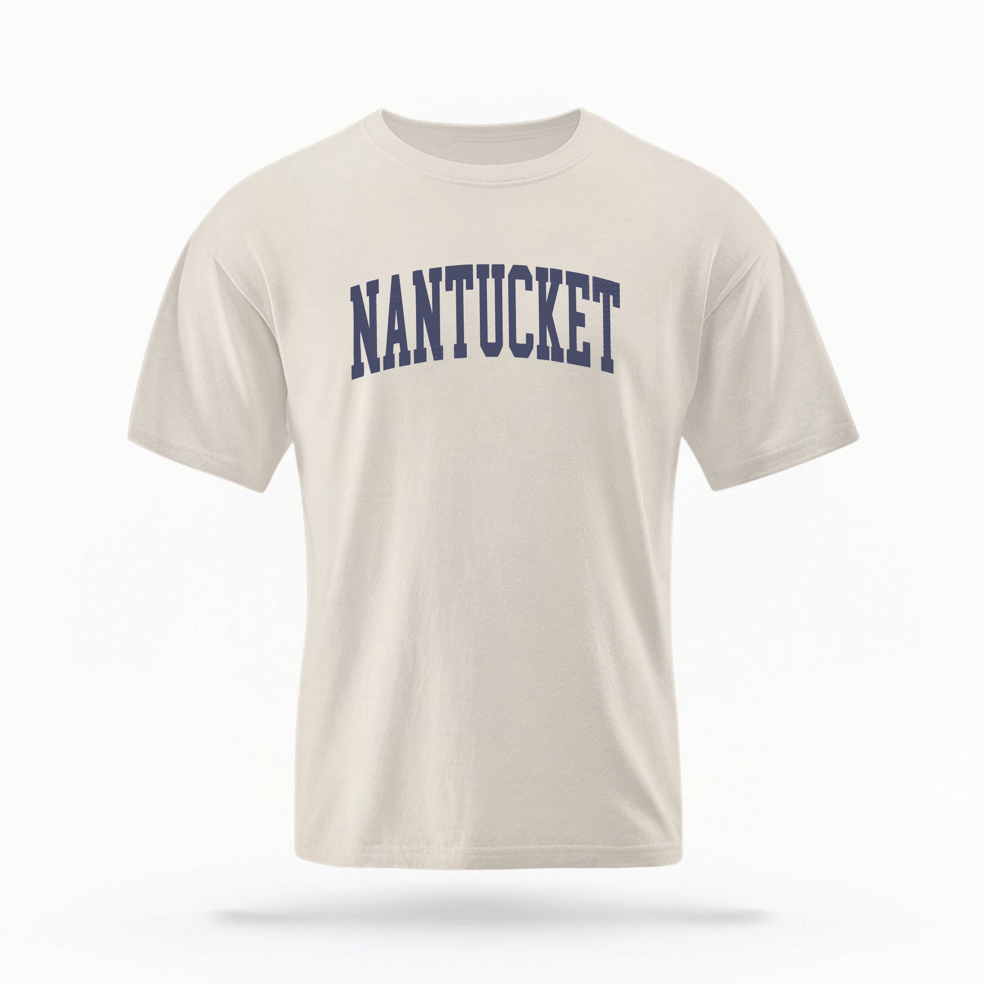 The Ivory Adult Unisex Nantucket Massachusetts Varsity Comfort Colors T-shirt lays flat on a white background. The ﻿Nantucket Massachusetts Varsity﻿ graphic is in bold Navy in a Collegiate Block style.
