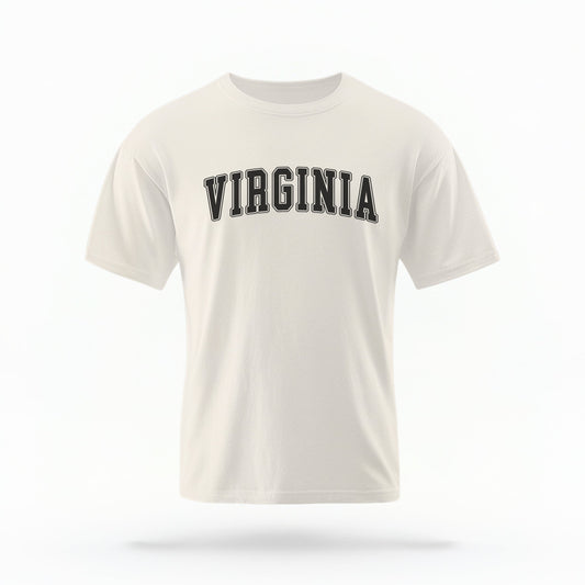 The ivory Unisex Virginia Varsity Comfort Colors T-shirt lays flat on a white background. The Virginia graphic is in bold black in a varsity offset style.
