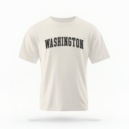 The ivory Unisex Washington Varsity Comfort Colors T-shirt lays flat on a white background. The Washington graphic is in bold black in a varsity offset style.