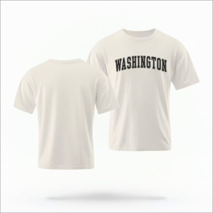 The ivory Unisex Washington Varsity Comfort Colors T-shirt lays flat on a white background. The Washington graphic is in bold black in a varsity offset style.