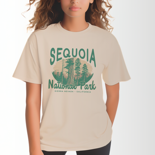A model wears the Ivory Adult Unisex Sequoia National Park Comfort Colors T-shirt.  The ﻿Sequoia National Park﻿ graphic is in bold Lifestyle in a Rustic Park style.