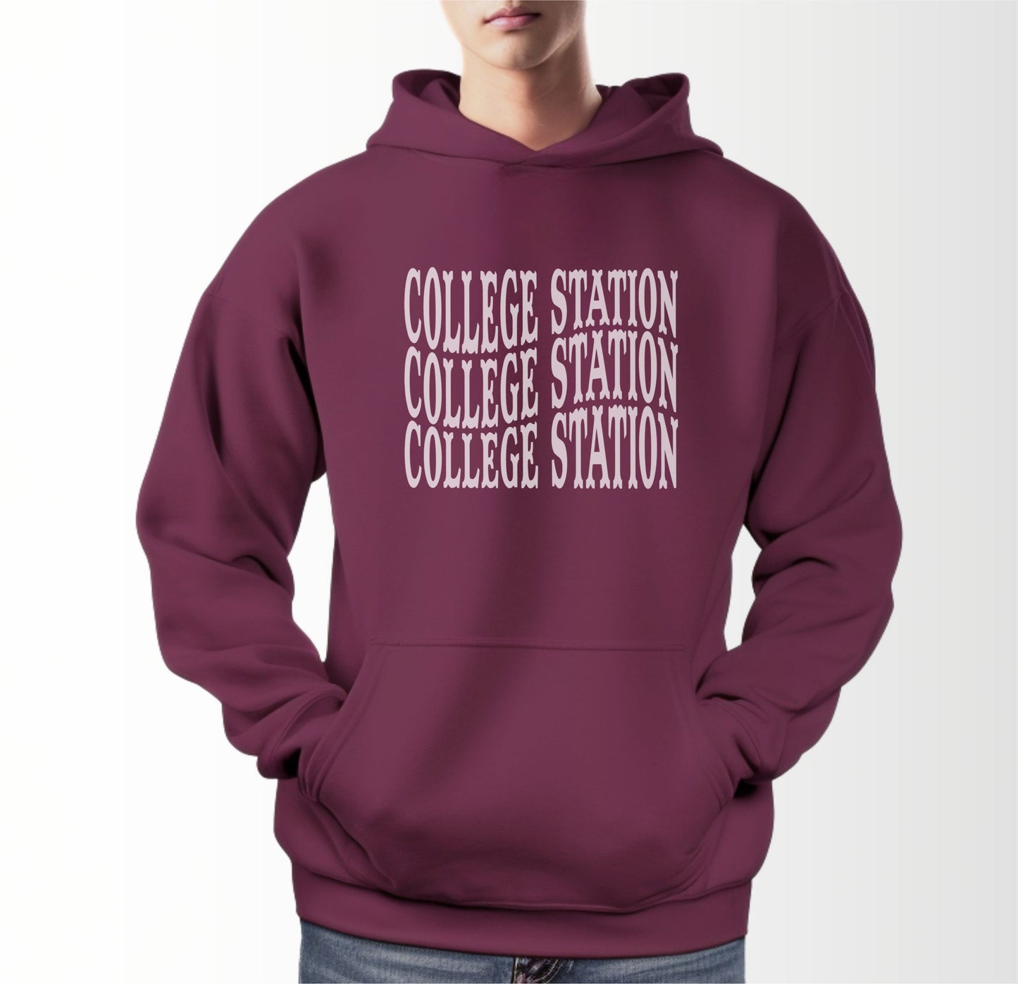 A model wears the Maroon Adult Unisex College Station Western Hooded Sweatshirt.  The ﻿College Station Western﻿ graphic is in bold White in a Western style.