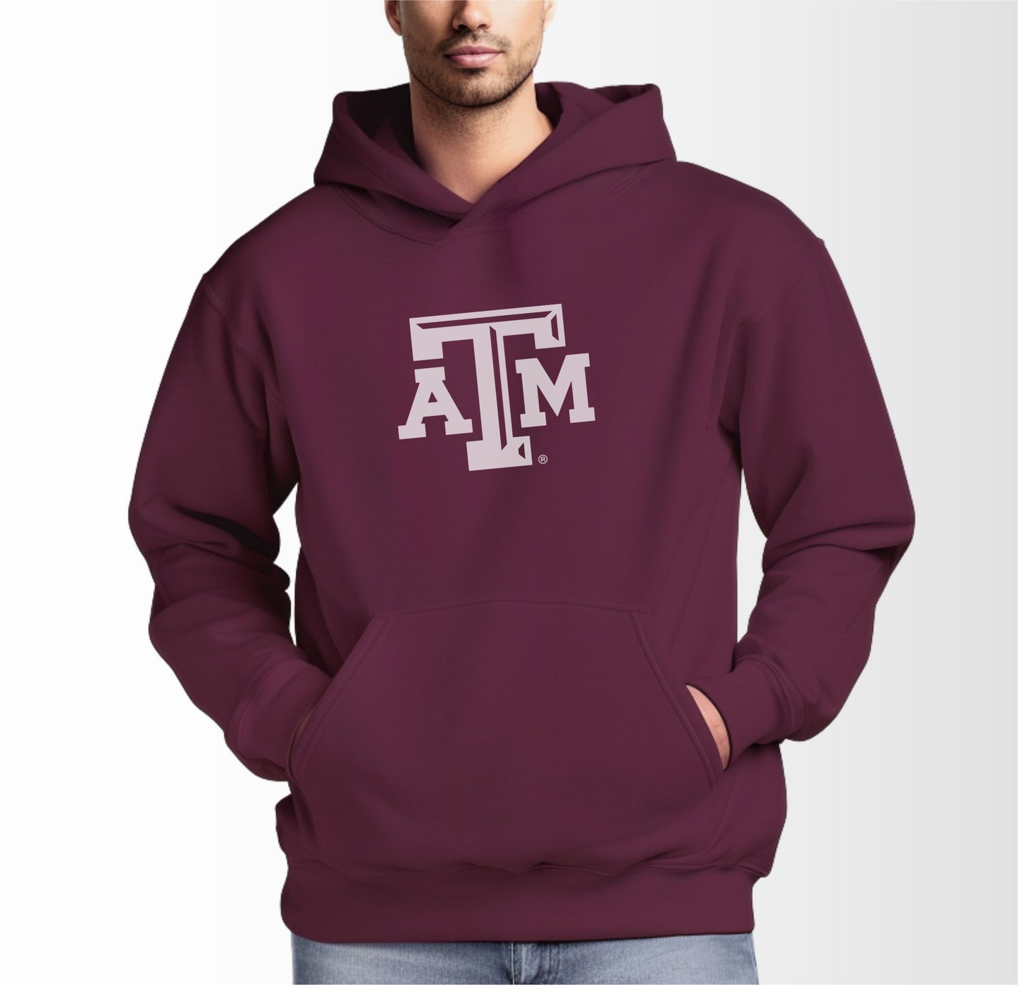 A model wears the Maroon Adult Unisex Texas A&M Logo Hooded Sweatshirt.  The ﻿Texas A&M Logo﻿ graphic is in bold White in a Varsity style.