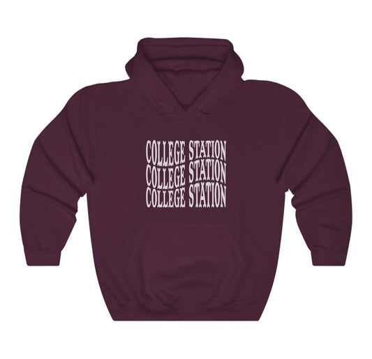 The Maroon Adult Unisex College Station Western Hooded Sweatshirt lays flat on a white background. The ﻿College Station Western﻿ graphic is in bold White in a Western style.