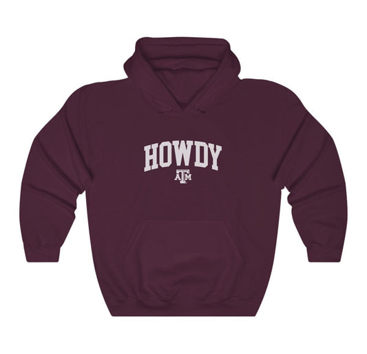 The Maroon Adult Unisex Texas A&M Howdy Varsity Hooded Sweatshirt lays flat on a white background. The ﻿Texas A&M Howdy Varsity﻿ graphic is in bold White in a Collegiate style.