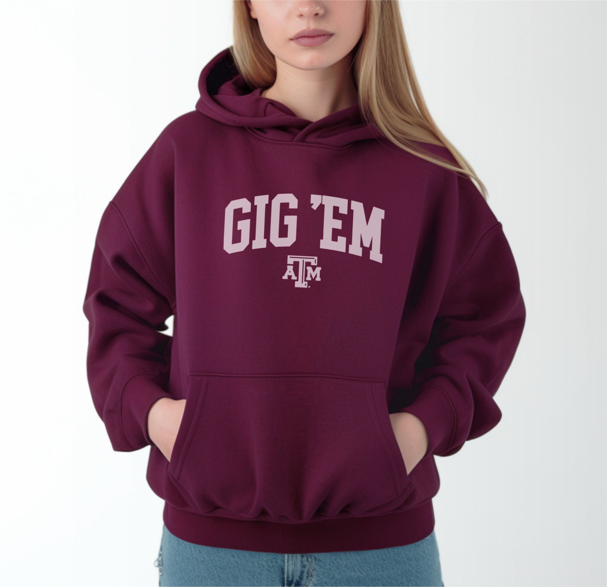 A model wears the Maroon Adult Unisex Texas A&M Gig 'Em Collegiate Hooded Sweatshirt.  The ﻿Texas A&M Gig 'Em Collegiate﻿ graphic is in bold White in a Collegiate style.