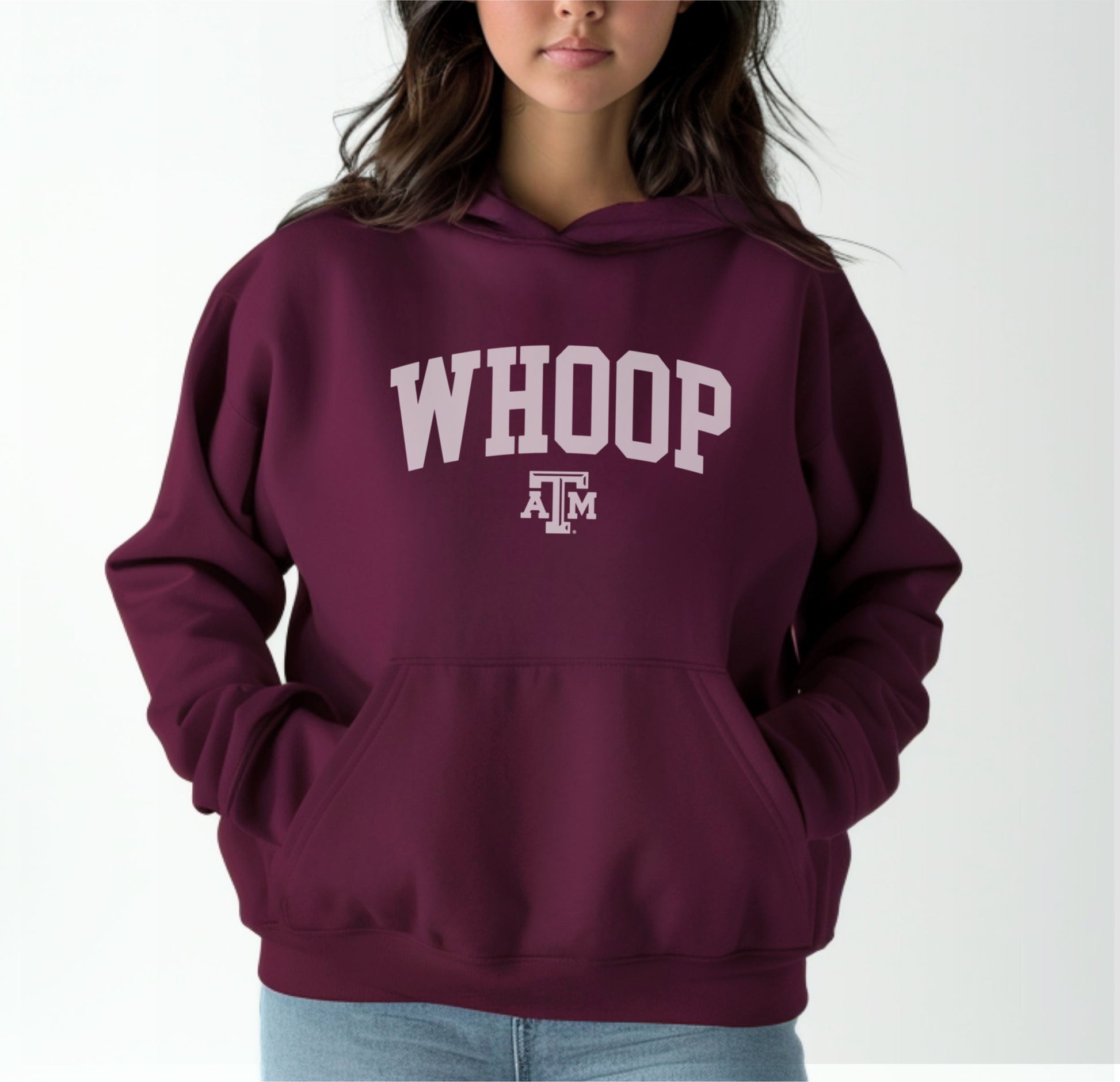 A model wears the Maroon Adult Unisex Texas A&M Whoop Collegiate Hooded Sweatshirt.  The ﻿Texas A&M Whoop Collegiate﻿ graphic is in bold White in a Varsity style.