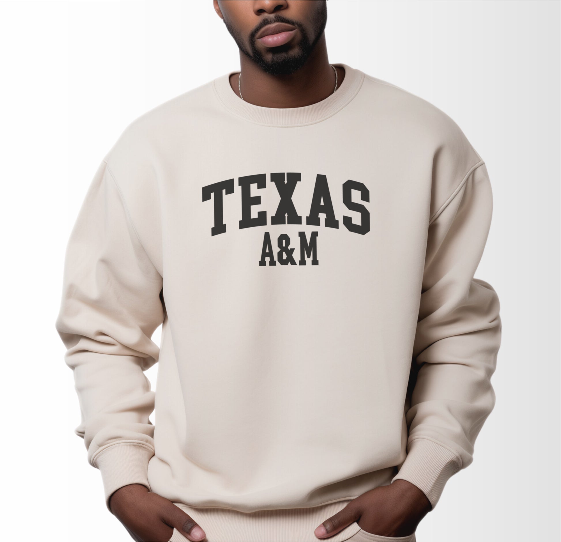 A model wears the Sand Adult Unisex Texas A&M Varsity Crewneck Sweatshirt.  The ﻿Texas A&M Varsity﻿ graphic is in bold Black in a Collegiate style.