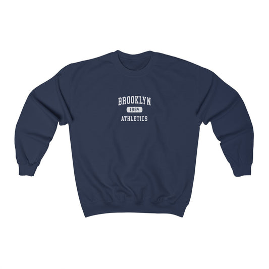 The Navy Brooklyn Athletics Crewneck Sweatshirt lays flat on a white background. The ﻿Brooklyn Athletics﻿ graphic is in bold Black in a Varsity style.