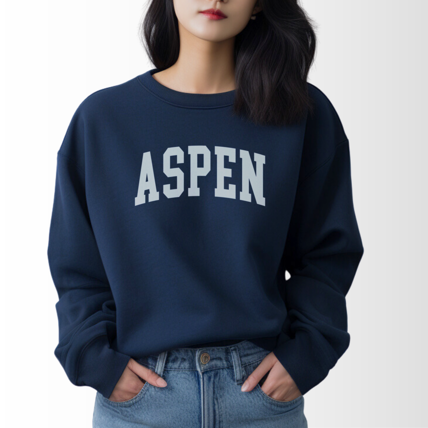 A model wears the Navy Aspen Colorado Varsity Crewneck Sweatshirt.  The ﻿Aspen Colorado Varsity﻿ graphic is in bold White in a Collegiate style.