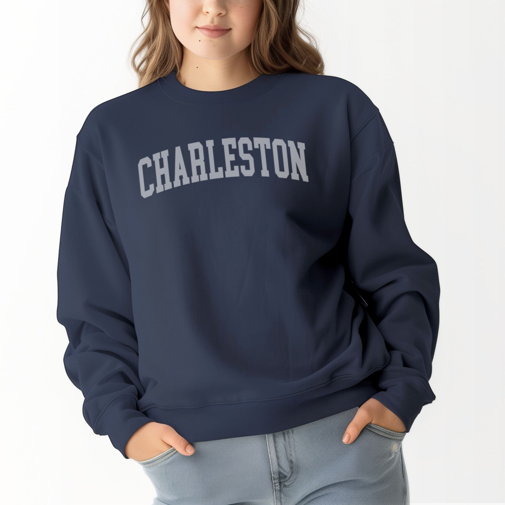 A model wears the Navy Adult Unisex Charleston SC Collegiate Crewneck Sweatshirt.  The ﻿Charleston SC Collegiate﻿ graphic is in bold White in a Varsity style.