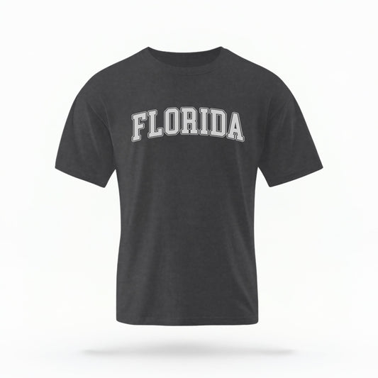 The pepper Adult Unisex Florida Varsity Comfort Colors T-shirt lays flat on a white background. The Florida graphic is in bold white in a varsity offset style.