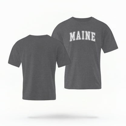 The Pepper Unisex Maine Varsity Comfort Colors T-shirt lays flat on a white background. The Maine graphic is in bold white in a varsity offset style.