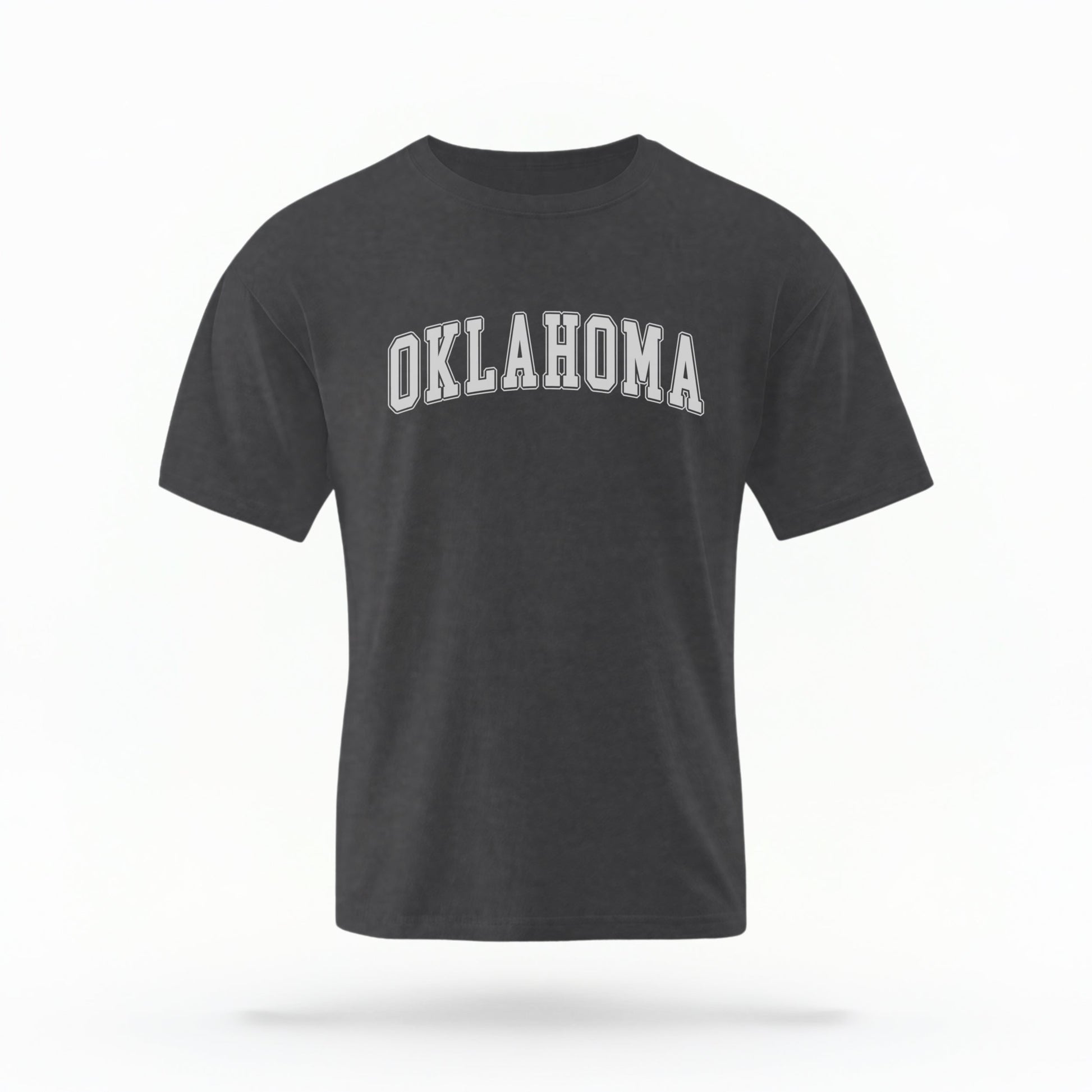 The Pepper Unisex Oklahoma Varsity Comfort Colors T-shirt lays flat on a white background. The Oklahoma graphic is in bold white in a varsity offset style.
