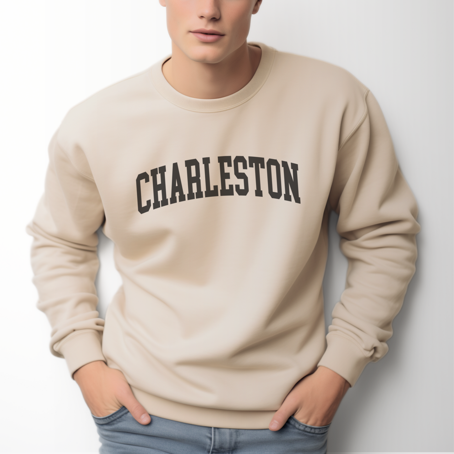 A model wears the Sand Adult Unisex Charleston SC Collegiate Crewneck Sweatshirt.  The ﻿Charleston SC Collegiate﻿ graphic is in bold Black in a Varsity style.