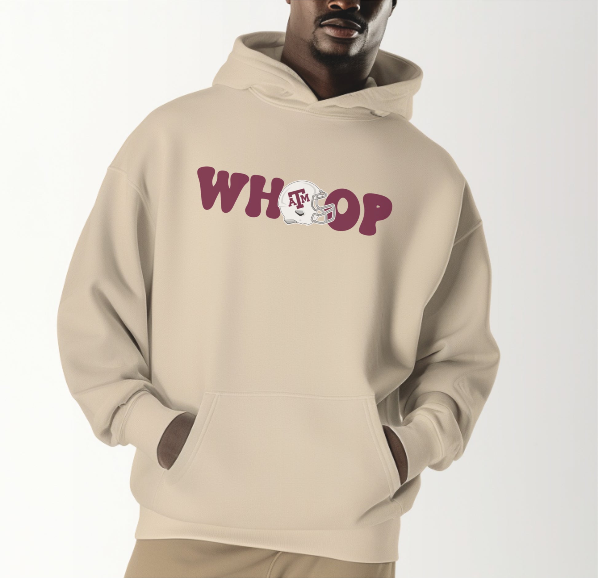 A model wears the Sand Adult Unisex Texas A&M Retro Whoop Hooded Sweatshirt.  The ﻿Texas A&M Retro Whoop﻿ graphic is in bold Black in a Vintage style.