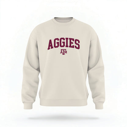 The Sand Unisex Texas A&M Aggies Collegiate Crewneck Sweatshirt lays flat on a white background. The ﻿Texas A&M Aggies Collegiate﻿ graphic is in bold maroon in a Collegiate style.