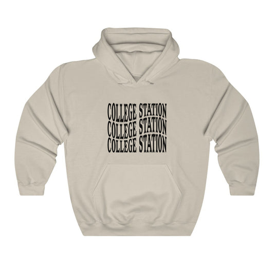 The Sand Adult Unisex College Station Western Hooded Sweatshirt lays flat on a white background. The ﻿College Station Western﻿ graphic is in bold Black in a Western style.