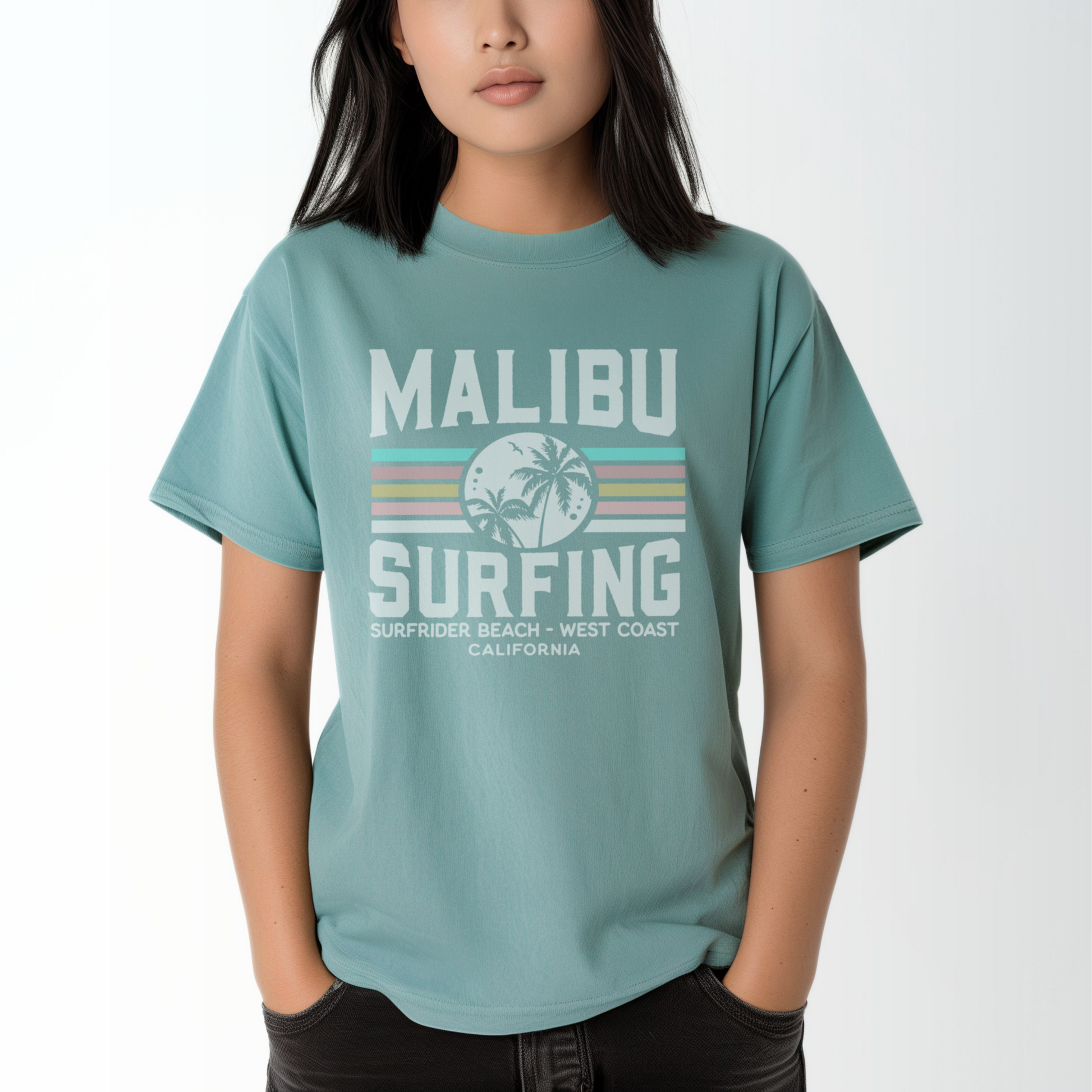 A model wears the Seafoam Adult Unisex Malibu California Surfing Comfort Colors T-shirt.  The ﻿Malibu California Surfing﻿ graphic is in bold Lifestyle in a Multicolor style.