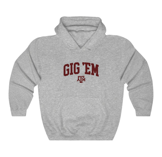 The Sport Grey Adult Unisex Texas A&M Gig 'Em Collegiate Hooded Sweatshirt lays flat on a white background. The ﻿Texas A&M Gig 'Em Collegiate﻿ graphic is in bold Maroon in a Collegiate style.