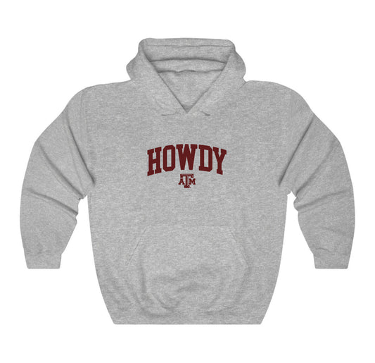 The Sport Grey Adult Unisex Texas A&M Howdy Varsity Hooded Sweatshirt lays flat on a white background. The ﻿Texas A&M Howdy Varsity﻿ graphic is in bold Maroon in a Collegiate style.