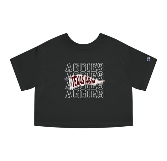 The Black Adult Womens Texas A&M Aggies Pennant Crop Top lays flat on a white background. The ﻿Texas A&M Aggies Pennant﻿ graphic is in bold White in a Varsity style.