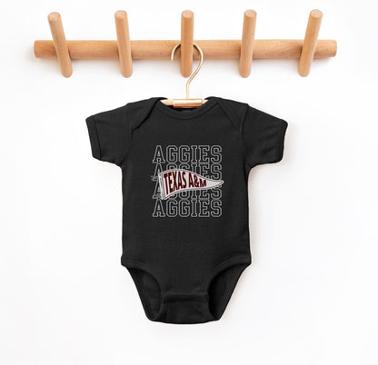 The Black Infant Unisex Texas A&M Aggies Pennant Bodysuit lays flat on a white background. The ﻿Texas A&M Aggies Pennant﻿ graphic is in bold White in a Varsity style.