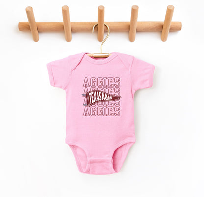 The Pink Infant Unisex Texas A&M Aggies Pennant Bodysuit lays flat on a white background. The ﻿Texas A&M Aggies Pennant﻿ graphic is in bold Maroon in a Varsity style.