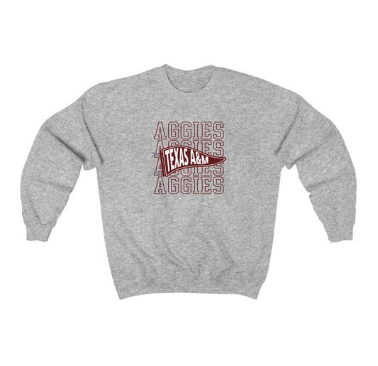 The Sport Grey Adult Unisex Texas A&M Aggies Pennant Crewneck Sweatshirt lays flat on a white background. The ﻿Texas A&M Aggies Pennant﻿ graphic is in bold Maroon in a Varsity style.