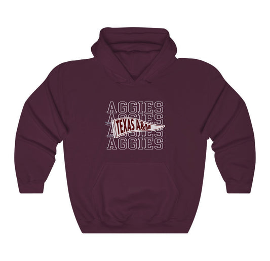 The Maroon Adult Unisex Texas A&M Aggies Pennant Hooded Sweatshirt lays flat on a white background. The ﻿Texas A&M Aggies Pennant﻿ graphic is in bold White in a Varsity style.