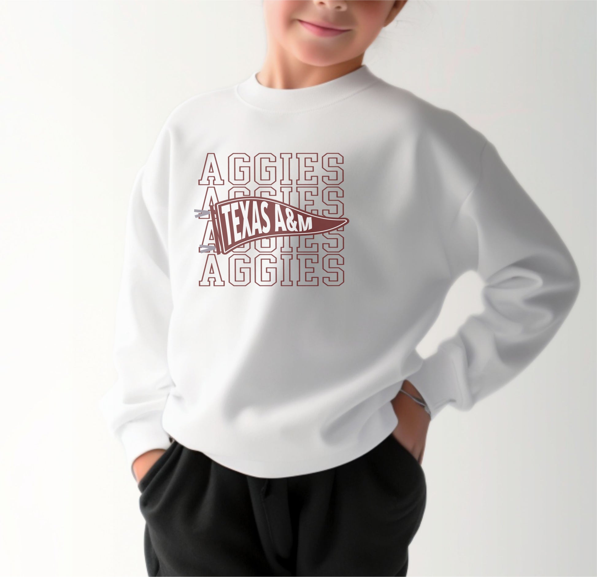 A model wears the White Youth Unisex Texas A&M Aggies Pennant Crewneck Sweatshirt.  The ﻿Texas A&M Aggies Pennant﻿ graphic is in bold Maroon in a Varsity style.