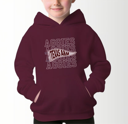 A model wears the Maroon Youth Unisex Texas A&M Aggies Pennant Hooded Sweatshirt.  The ﻿Texas A&M Aggies Pennant﻿ graphic is in bold White in a Varsity style.