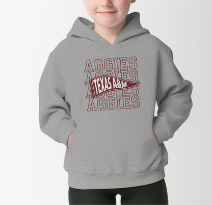 A model wears the Sport Grey Youth Unisex Texas A&M Aggies Pennant Hooded Sweatshirt.  The ﻿Texas A&M Aggies Pennant﻿ graphic is in bold Maroon in a Varsity style.