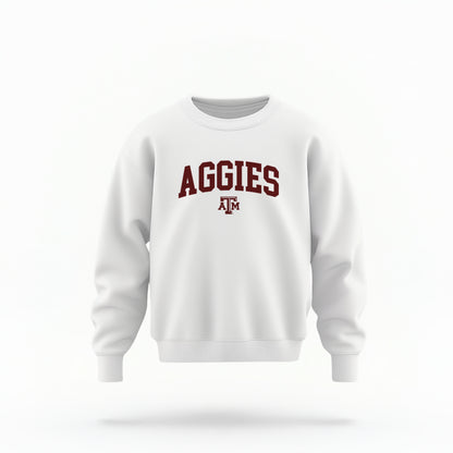 The White Youth Unisex Texas A&M Aggies Collegiate Crewneck Sweatshirt lays flat on a white background. The ﻿Texas A&M Aggies Collegiate﻿ graphic is in bold Maroon in a Varsity style.