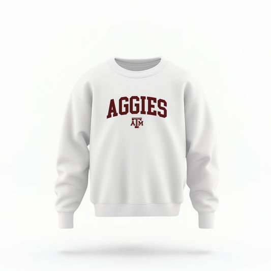 The White Youth Unisex Texas A&M Aggies Collegiate Crewneck Sweatshirt lays flat on a white background. The ﻿Texas A&M Aggies Collegiate﻿ graphic is in bold Maroon in a Varsity style.