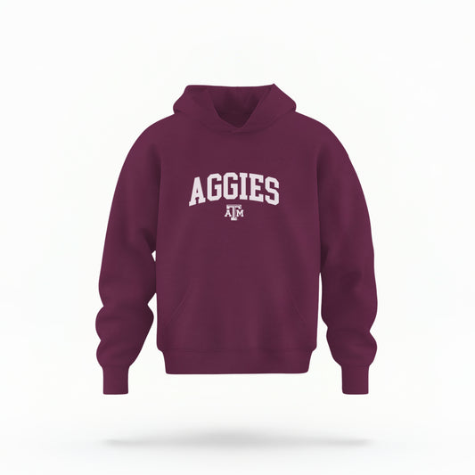 The Maroon Youth Unisex Texas A&M Aggies Collegiate Hooded Sweatshirt lays flat on a white background. The ﻿Texas A&M Aggies Collegiate﻿ graphic is in bold White in a Varsity style.